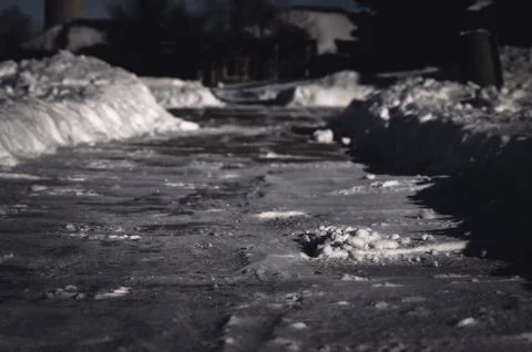 Selective focus ground level view of snow blown sidewalk section with path Stock Photos