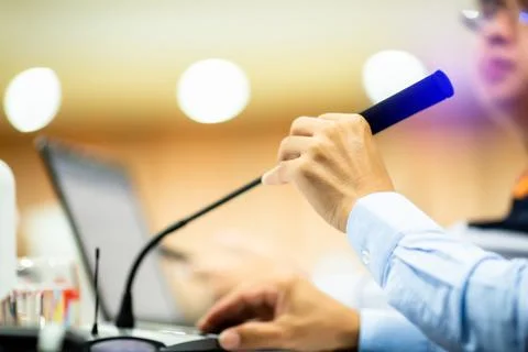 Selective focus to hand and desktop wireless conference microphones with blur Stock Photos