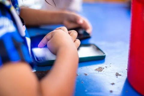 Selective focus to hand of child with smartphone used to play games or chil.. Stock Photos