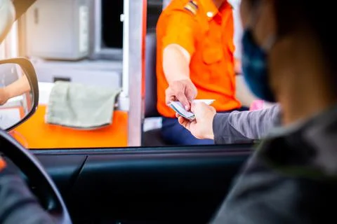 Selective focus to hand of driver pay for the expressway. Man pays money to a Stockfoto's