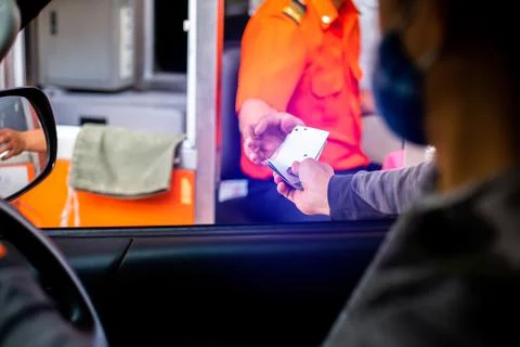 Selective focus to hand of driver pay for the expressway. Man pays money to a Stock Photos