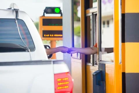 Selective focus to hand of driver pay for the expressway. Driver pays money t Stock Photos
