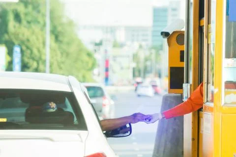 Selective focus to hand of driver pay for the expressway. Driver pays money t Stock Photos