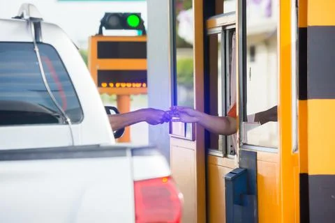 Selective focus to hand of driver pay for the expressway. Driver pays money t Stockfoto's