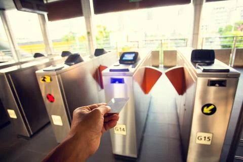 Selective focus to hand of passenger using smart card to open automatic gate  Stock Photos
