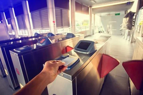 Selective focus to hand of passenger using smart card to open automatic gate  Stock Photos