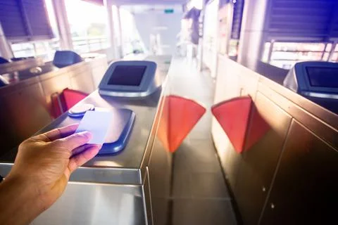 Selective focus to hand of passenger using smart card to open automatic gate  Stock Photos
