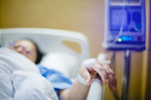 Selective focus to hand of patient draw to Infusion pumps and saline bag in h Stock Photos