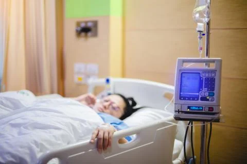 Selective focus to hand of patient draw to Infusion pumps and saline bag in h Stock Photos