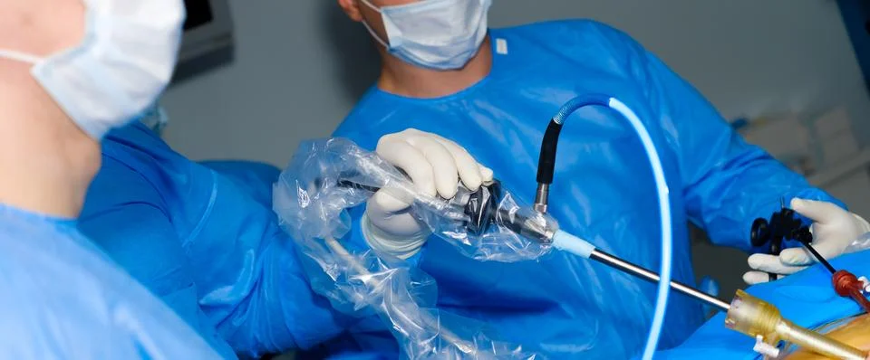 Selective focus on the hand of a surgeon operating a laparoscopic manipulator. Stock Photos