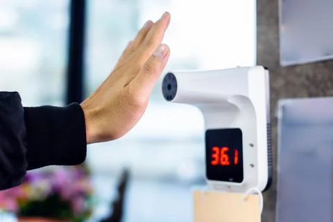 Selective focus to hand with temperature scanning machine for fever. Stock Photos