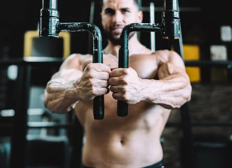 Selective focus on the hands of a man exercising on a machine in a gym Stock Photos