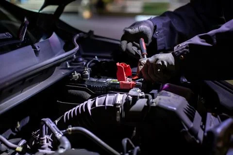 Selective focus to Hands of a mechanic using a hand tool to tighten a car b.. Stock Photos