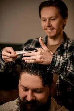 Selective focus on hands of professional barber cutting and styling hair with Foto stock