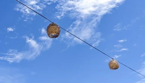 Selective Focus. The Hanging Handmade Wicker Lanterns on the Wire. Stock Photos