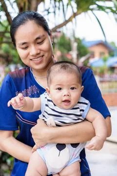 Selective focus on happy child boy and young woman holding adorable baby boy  Stock Photos