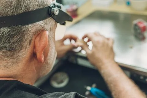 Selective focus on the head of a man working in a dental laboratory Stock Photos