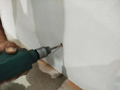 Selective focus a hole in the wall being drilled with a power drill. 스톡 사진