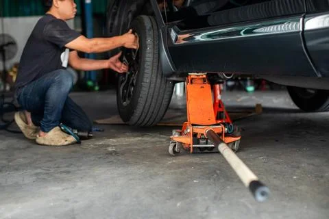 Selective focus to hydraulic floor jack with blurry professional mechanic i.. Stock Photos