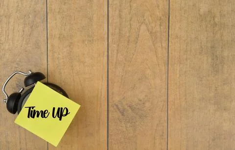 Selective focus image of alarm clock with Time Up wording on a wooden backgro Stock Photos