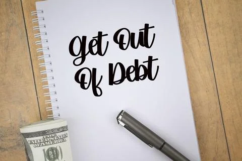 Selective focus image of bank note and pen with get out of debt wording on wo Stock Photos