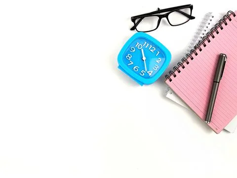 Selective focus image of clock, spectacles and notebook on a white background Stock Photos