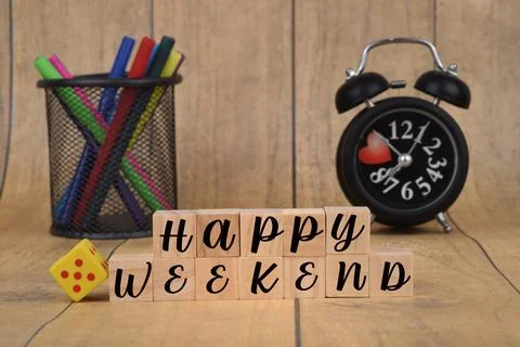 Selective focus image of Happy Weekend on a blur background of alarm clock an Stock Photos