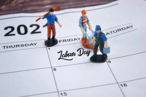 Selective focus image of human miniature on a calendar with Labour Day wordin Stock Photos
