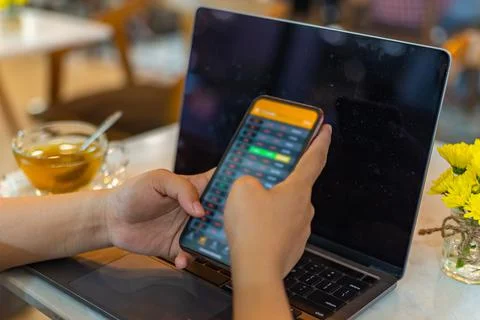 Selective focus image of human using smartphone checking stock exchange index 写真素材