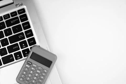 Selective focus image of laptop and calculator on white background. Business  Stock Photos