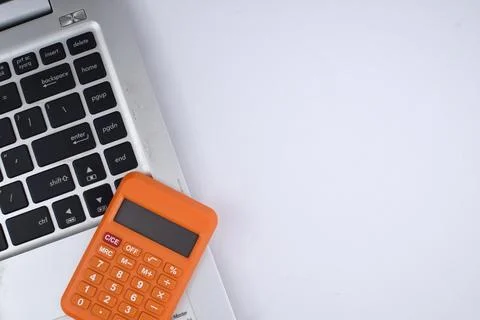 Selective focus image of laptop and calculator on white background. Business  Stock Photos