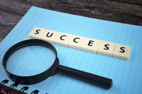 Selective focus image of magnifying glass with SUCCESS wording on a paper. Mo Stock Photos