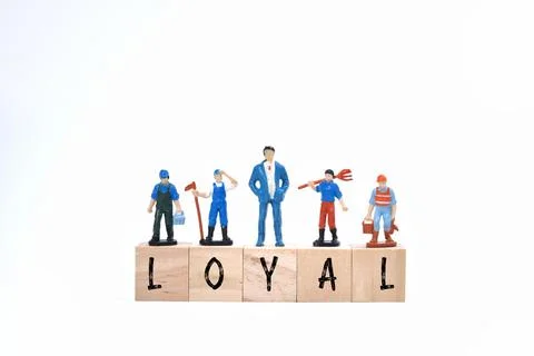 Selective focus image of miniature people with LOYAL wording on a white backg Stock Photos