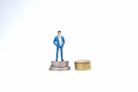 Selective focus image of miniature rich people standing on coin money. Busine Stock Photos