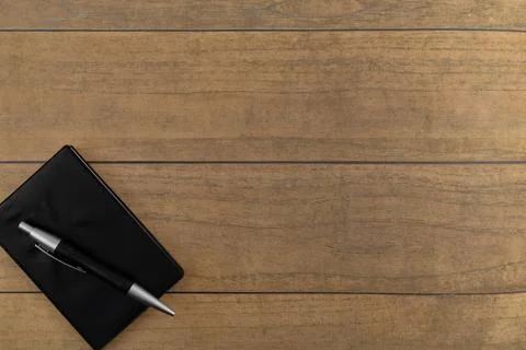 Selective focus image of notebook and pen on a wooden background with copy sp Stock Photos