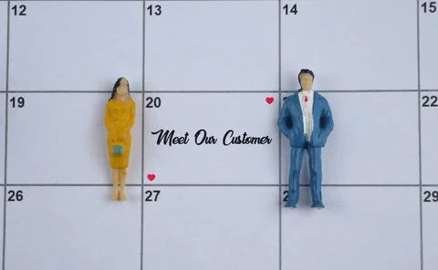Selective focus image of people miniature on a calendar with Meet Our Custome Stock Photos