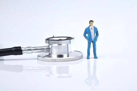 Selective focus image of people miniature with stethoscope on a white backgro Stock Photos