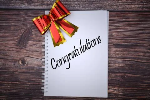 Selective focus image of red shiny ribbon with Congratulations wording on a w Stock Photos