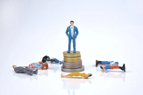 Selective focus image of rich people miniature standing on stack of coins wit Stock Photos