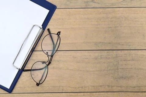 Selective focus image of spectacles and file holder on wooden background with Stock Photos