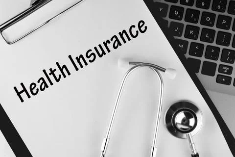 Selective focus image stethoscope and laptop with Health Insurance wording. M Stock Photos