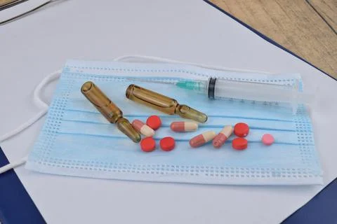 Selective focus image of syringe, vial injection and pills tablet on a face m Stock Photos