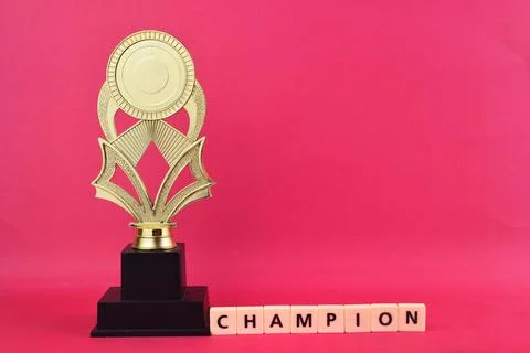 Selective focus image of trophy with champion wording on pink background. Stock Photos