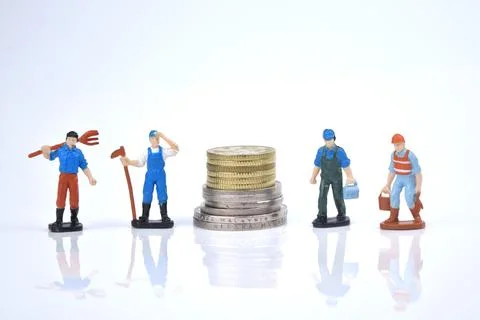 Selective focus image of working person miniature with stack of coins on a wh Stock Photos