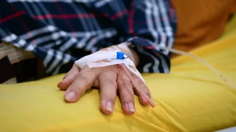 Selective focus of Infusion pump feeding IV drip into patients arm Stock Footage 281576670
