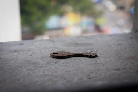 Selective Focus on iron key on concrete surface and bright background Stock Photos