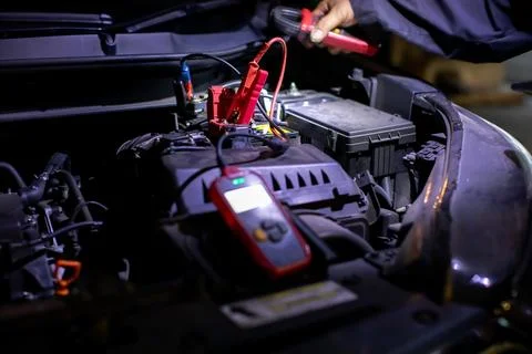 Selective focus to Jumper cable with Auto mechanic using a digital battery .. Stock Photos