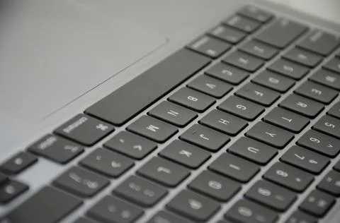 Selective focus keyboard of laptop. Side view device with trackpad. Stock Photos