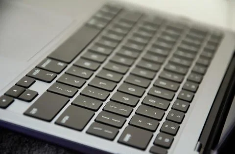 Selective focus keyboard of laptop. Side view modern ultralight device. Stock Photos
