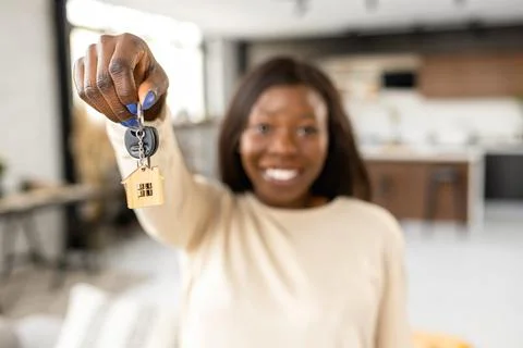 Selective focus at keys in hand of happy smiling African-American woman Stock Photos